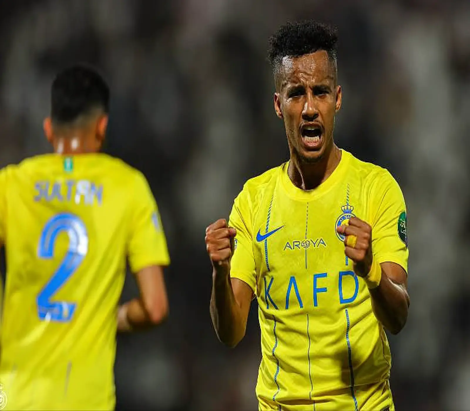 لاعب فريق النصر، عبد الإله العمري، يحتفل بحماس بقميصه الأصفر خلال مباراة كرة قدم.